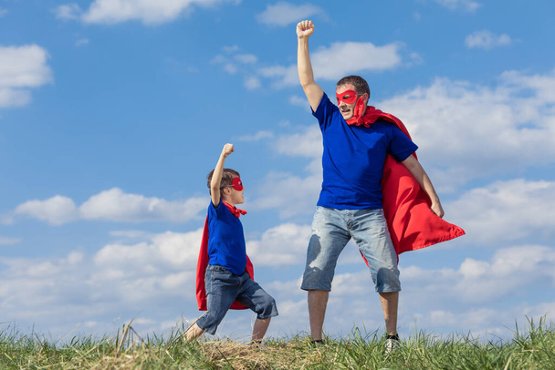 Father and son playing superhero at the day time. People having fun outdoors. Concept of friendly family. - Foto, Imagen