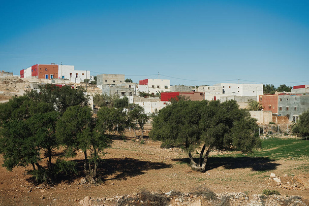 Повітряний вид на гарне місто з барвистими будинками і релігійними будівлями з зеленими деревами на півночі Марокко (Африка). - Фото, зображення