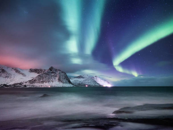 Polarlichter, Senja-Inseln, Norwegen. Nordlichter, Berge und Spiegelung auf dem Wasser. Winterlandschaft bei Polarlicht. Norwegen-Reise - Bild - Foto, Bild