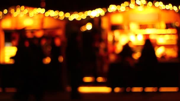 Καλλιτεχνική παρουσίαση των ανθρώπων σε μια αγορά το βράδυ, νύχτα. Δυνατά πίσω φώτα. Ψώνια. Περπατώντας. Σιλουέτες, σκιές. Μετακίνηση. - Πλάνα, βίντεο