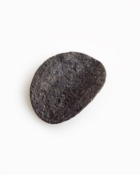 Один натуральный черный хрустящий картофельный чип
 - Фото, изображение