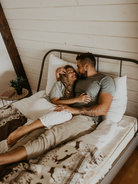 Beautiful loving couple kissing in bed - Foto, Imagen