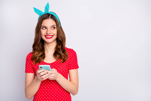 Portrait of positive cheerful girl use smart phone want type social network news look copyspace dream dreamy wear stylish trendy blue outfit isolated over grey color background - 写真・画像