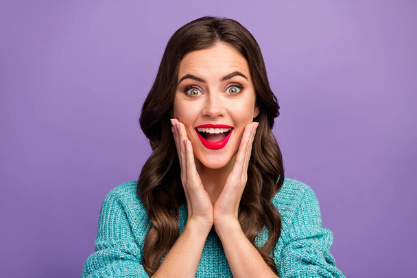 Closeup photo of beautiful pretty curly lady red lips good mood listen amazing news open mouth arms on cheeks wear blue knitted pullover isolated purple color background - Foto, imagen