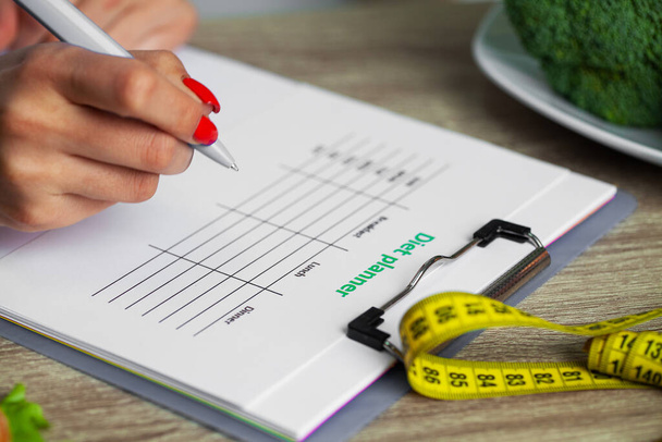Dietetyk przygotowuje plan diety dla kobiety z nadwagą - Zdjęcie, obraz
