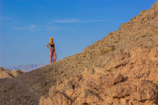 travel concept woman portrait stay on a dry ground desert rock hill diagonal line horizon προβολή αποβλήτων περιβάλλον θέρμανσης γης και έντονο μπλε ουρανό αντίγραφο χώρου για το κείμενό σας εδώ - Φωτογραφία, εικόνα