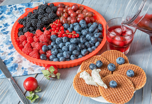 Different types of ripe berries - blueberries, raspberries, red currants, mulberries, a drink from berries and waffles with cheese. Appetizing snack with berries. - Photo, Image