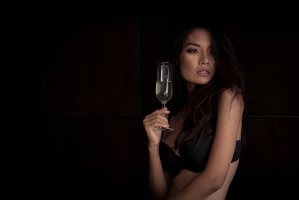 donna sexy che tiene bicchieri di vino in tono scuro
 - Foto, immagini