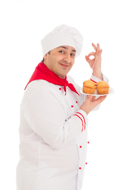 chef holding plate with 4 muffins wearing red and white uniform - Foto, Bild