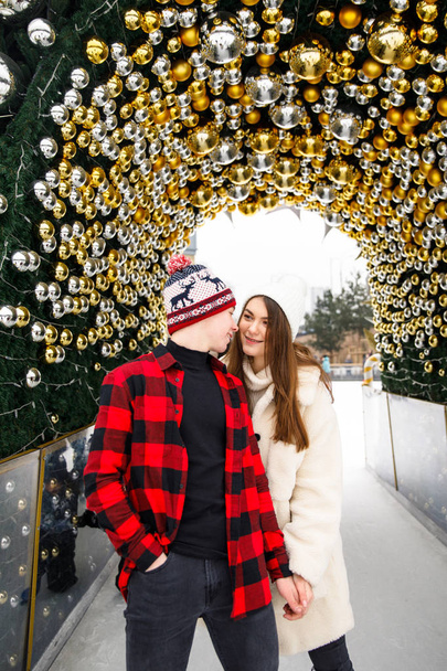 portraits of young couple lovers posing on Christmas decorated tree and ice rink background - Fotoğraf, Görsel