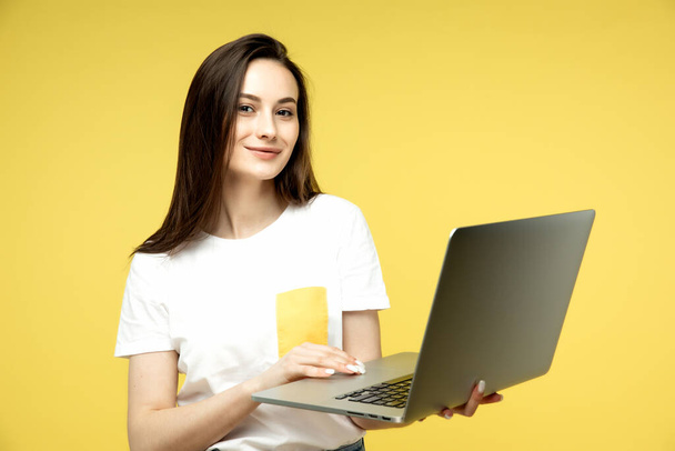 woman with laptop on yellow background, copy space. - Photo, image
