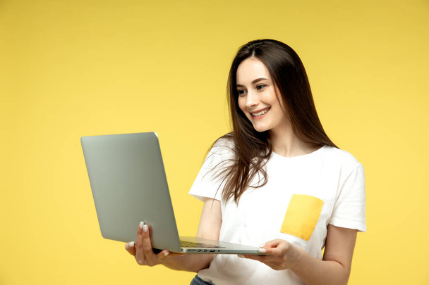 Surprised business women with laptop on yellow background. - Fotó, kép