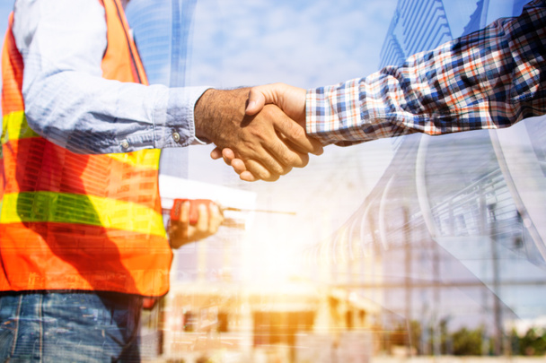 Architect contractor shaking hands with client at construction site  - Photo, Image
