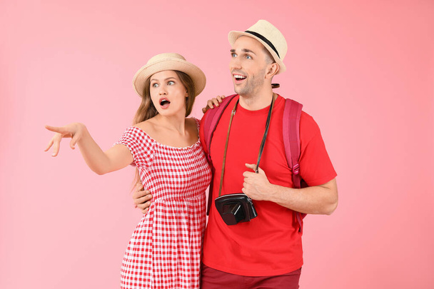 Couple of surprised tourists on color background - Fotoğraf, Görsel