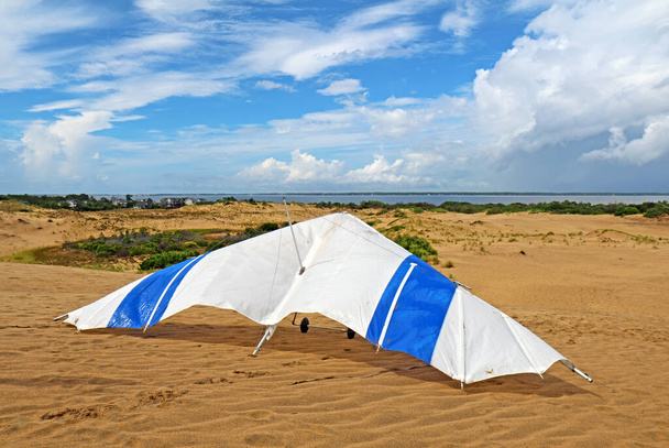 Deltaplane sur le sable du Jockeys Ridge State Park à Nags Tête sur les rives extérieures de la Caroline du Nord avec des nuages spectaculaires, des dunes et le détroit d'Albemarle en arrière-plan
 - Photo, image