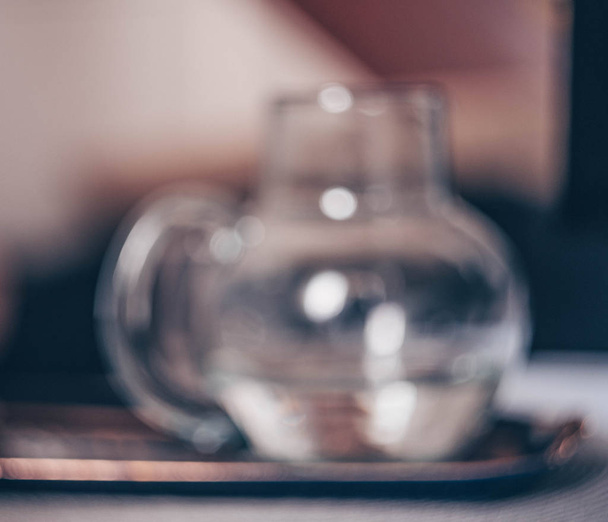 Defocused Glass jug of water on colourful background. Bokeh effect, soft focus. Top view with copy space. - Photo, Image