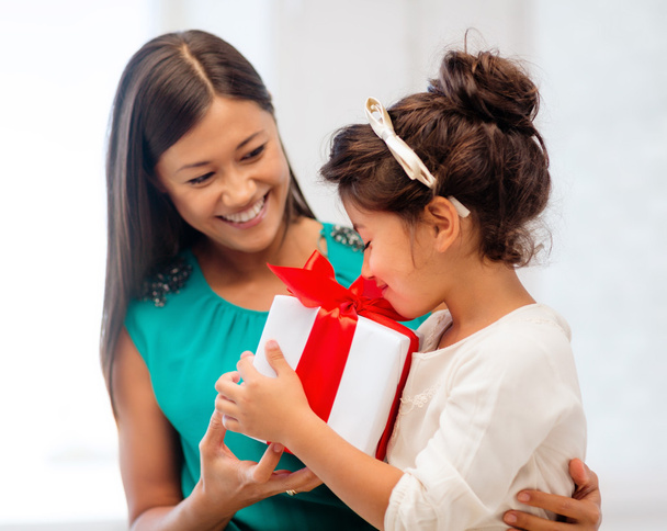Happy mother and child girl with gift box - Foto, imagen