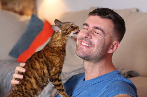 Exotische Katze spielt mit seinem hübschen Besitzer - Foto, Bild