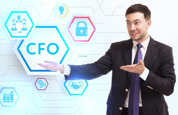 Business, Technology, Internet and network concept. Young businessman working on a virtual screen of the future and sees the inscription: CFO - Фото, изображение