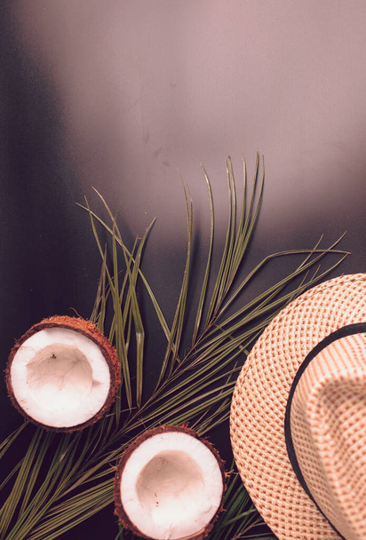 Summer composition with neon lights. Tropical palm leaves, hat, coconut on a dark background. The concept of the summer season, parties and heat. Flat lay, top view, copy space - Fotoğraf, Görsel