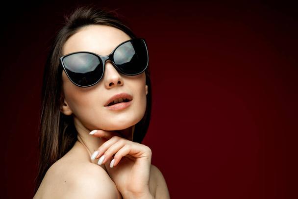 portrait of young beautiful slim woman in sexy dress with sensual lips in studio wearing sunglasses smiling and posing - Φωτογραφία, εικόνα