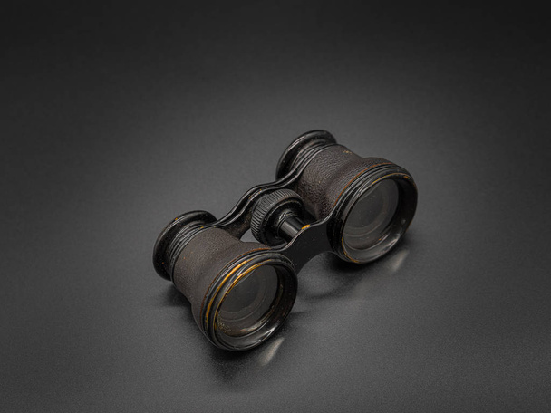 Antique opera glasses isolated on dark background. Black small vintage binocular. - Foto, Imagem