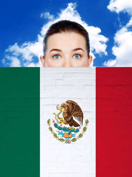 жіноче обличчя за стіною з мексиканським прапором
 - Фото, зображення