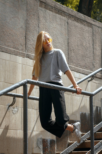 Oszałamiająca blondynka dziewczyna nastolatek przypadkowo ubrany pozowanie w podziemiu - Zdjęcie, obraz