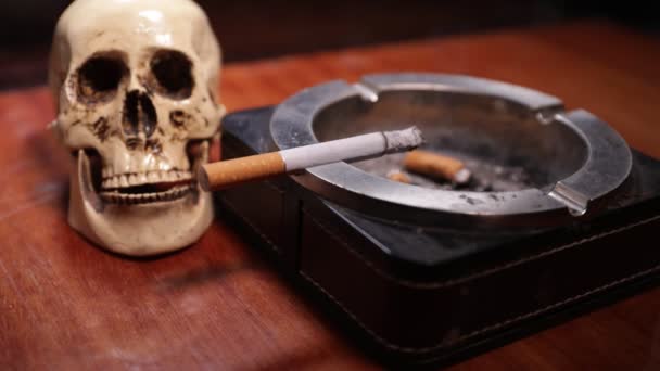 Non si fuma. Decorazione creativa tavolo opere d'arte con sigarette. Le sigarette causano il cancro e uccidono. Teschio di natura morta e sigarette. Focus selettivo - Filmati, video