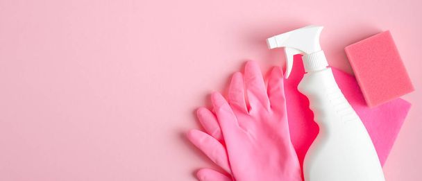 Cleaning supplies on pink background. Cleaning service banner design with spray bottle, pink gloves and sponge. Housecleaning services concept. - Фото, изображение
