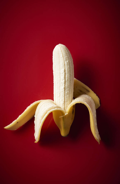 Peeled Banana on red background - Фото, зображення