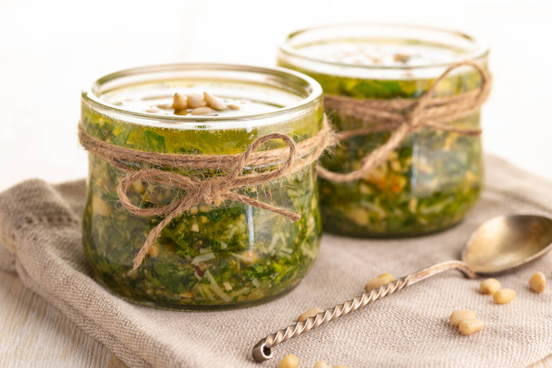 Green pesto sauce. Classic Italian Greens Sauce. Preservation in a glass jar. Close up.  - Φωτογραφία, εικόνα
