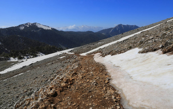 landscape with pathway in mountains among snow and stones. Take it in Turkey on Likya Yolu tourist walkway - Photo, Image