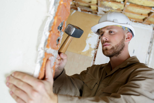 a builder with a hammer - Фото, изображение