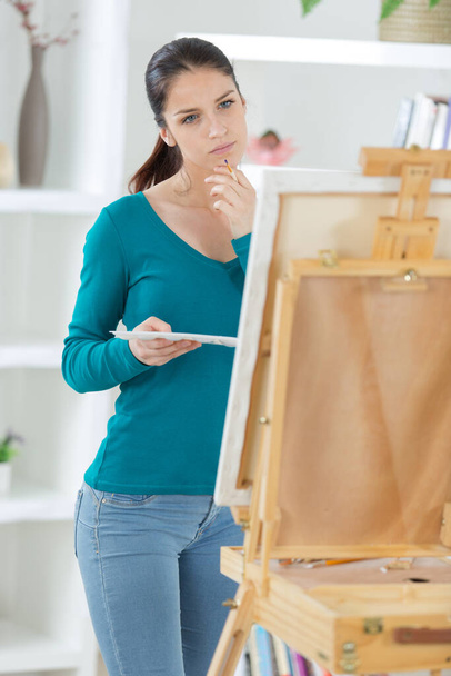 serious young woman painting at art studio - Zdjęcie, obraz