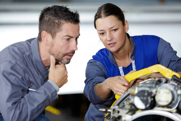mecánicos masculinos y femeninos trabajando juntos - Foto, Imagen