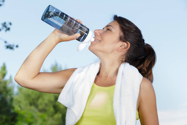 fitness woman drinking water after jogging in the morning - Foto, Imagem