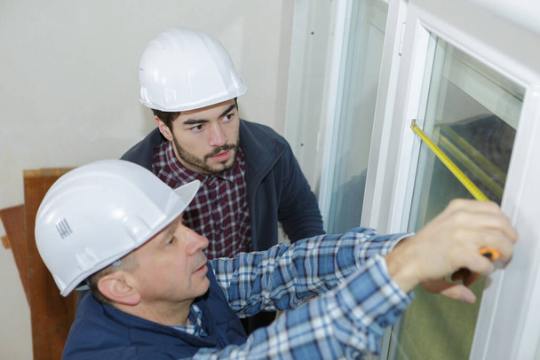 Bauarbeiter montieren neue Fenster im Haus - Foto, Bild