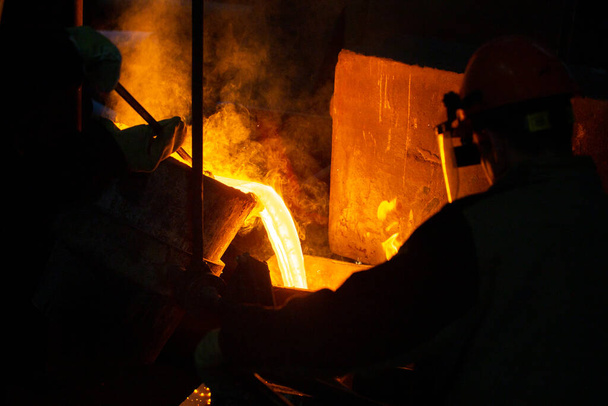 Close-up view of industrial chill casting. The process of for filling out mold with molten metal. - Photo, Image