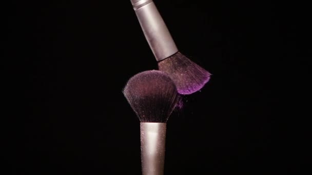 Make up brush with colored purple powderon at black background Slow Motion - Séquence, vidéo