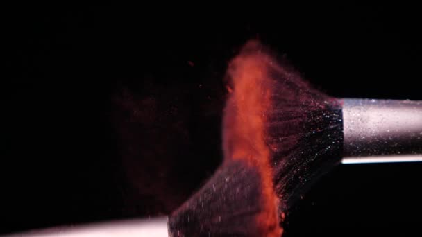 Make up brush with colored red powderon at black background Slow Motion - Filmati, video