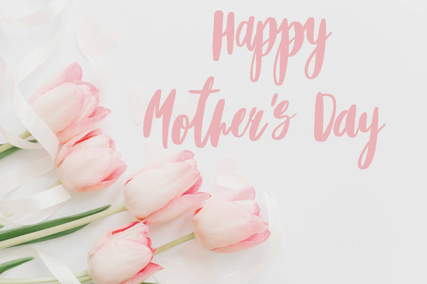 Szczęśliwego Dnia Matki. Szczęśliwy dzień matki tekst i różowe tulipany kwiatowa granica na białym tle. Stylowy, miękki wizerunek. Kwiatowa kartka z życzeniami. Szczęśliwego Dnia Matki. Pismo odręczne - Zdjęcie, obraz