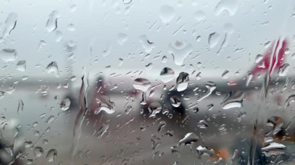 Κοντινό πλάνο 4k βίντεο με σταγόνες βροχής να πέφτουν σε βρεγμένο φινιστρίνι αεροπλάνου στο αεροπλάνο - Πλάνα, βίντεο