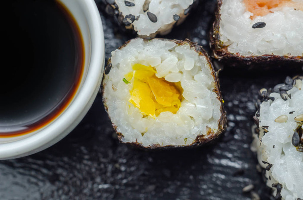 Keverjük össze a vega sushi és hal sushi a fekete kő lemez, japán étel - Fotó, kép