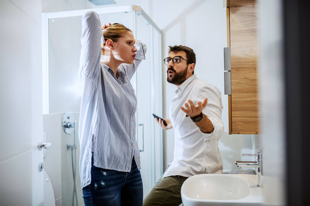 Couple getting ready for work and they are arguing. Bathroom interior, morning time. - Foto, Imagen