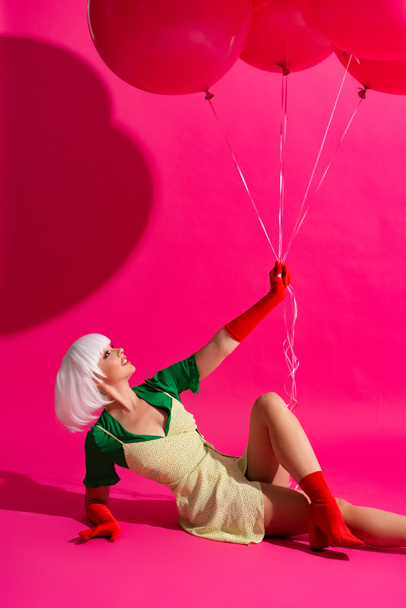 beautiful fashionable girl in white wig holding balloons on pink - Foto, imagen