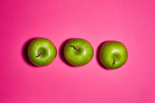 Green apple on pink background. Flat lay, top view, copy space . Food dietary concept. - Фото, зображення