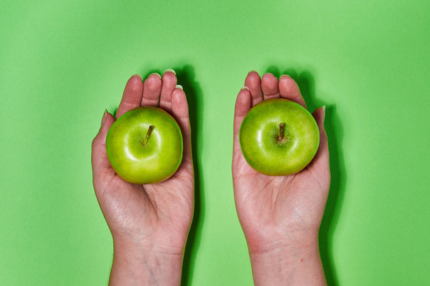 Zitrone in der Hand auf grünem Hintergrund. Flache Lage, Draufsicht, Kopierraum. Ernährungskonzept. - Foto, Bild