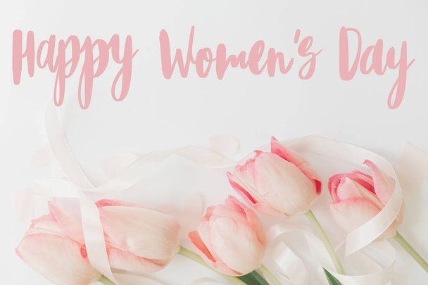 Hyvää naistenpäivää. Hyvää naistenpäivää teksti vaaleanpunainen tulppaanit, kukka onnittelukortti. Tyylikäs hellä kuva. Käsin kirjoitettua tekstiä. Kansainvälinen naistenpäivä, 8 maaliskuu - Valokuva, kuva