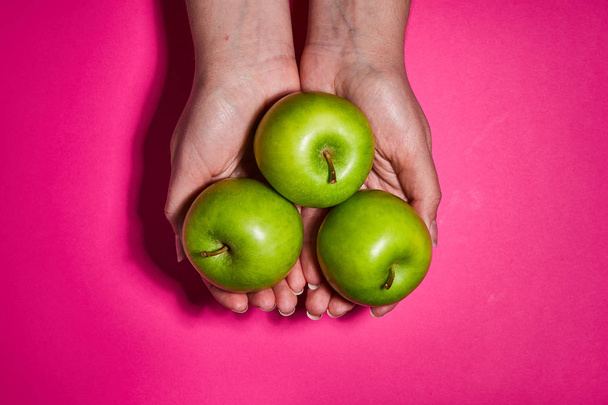 Lemon in hand on pink background. Flat lay, top view, copy space . Food dietary concept. - 写真・画像